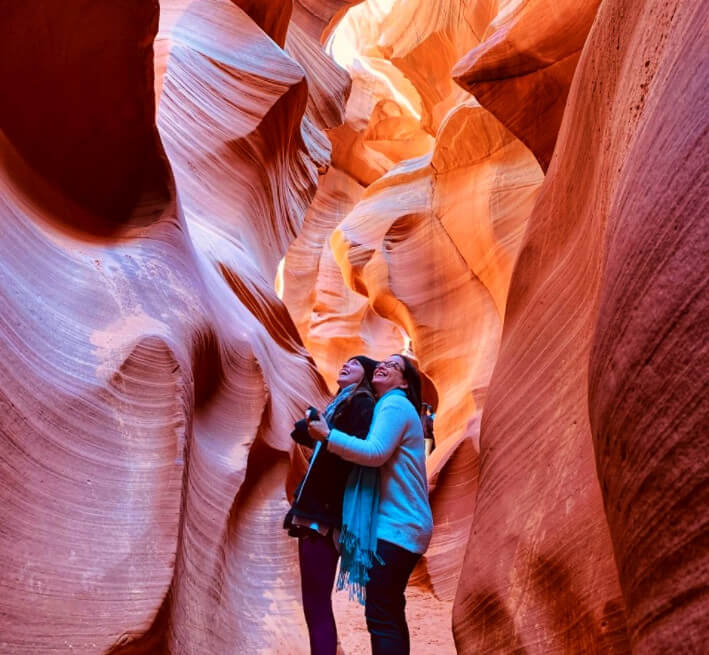Two women take a photo in Antelope Canyon